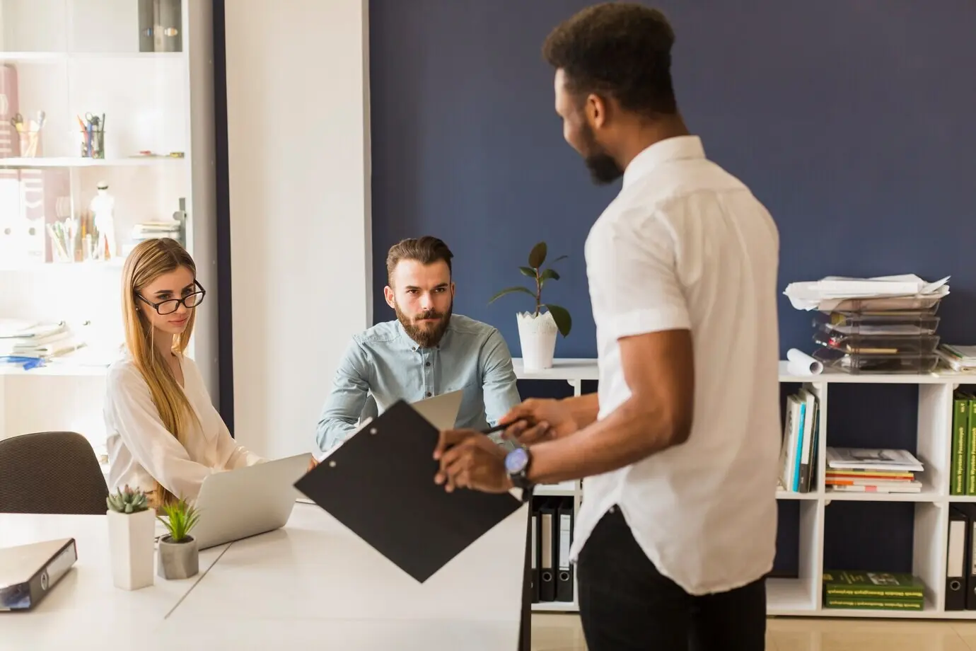 Мужчина с планшеткой объясняет стратегию.